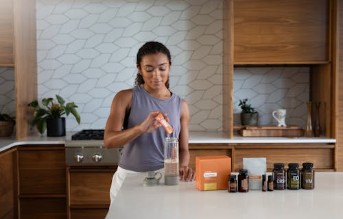 Free A woman in a kitchen making a drink Stock Photo