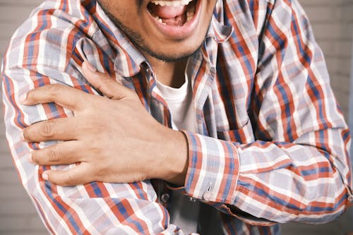 Free Close-up Photo of an aching Man holding his Shoulder Stock Photo